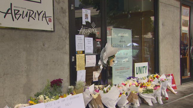 Flowers and signs placed in front of a restaurant at a memorial site for Eiwa Kwon, a pregnant Seattle restaurant owner who was murdered in the Belltown neighborhood on June 13, 2023. (KOMO)