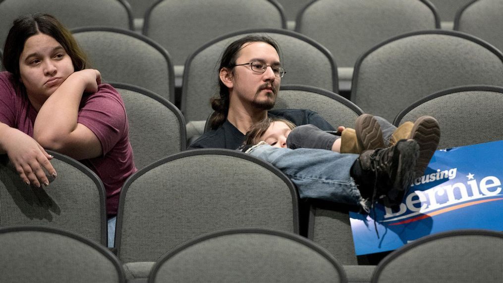 Jeff Lopez holds his son, Tristan, 4, as they and Jeff's wife, Jessika, sit in an area for Bernie Sanders supporters during the Woodbury County Third Precinct Democratic caucus, Monday, Feb. 3, 2020, at West High School in Sioux City, Iowa. (Tim Hynds/Sioux City Journal via AP)