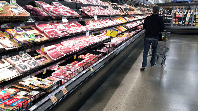 FILE - In this May 10, 2020 file photo, a shopper pushes his cart past a display of packaged meat in a grocery store in southeast Denver.{&nbsp;} (AP Photo/David Zalubowski, File)